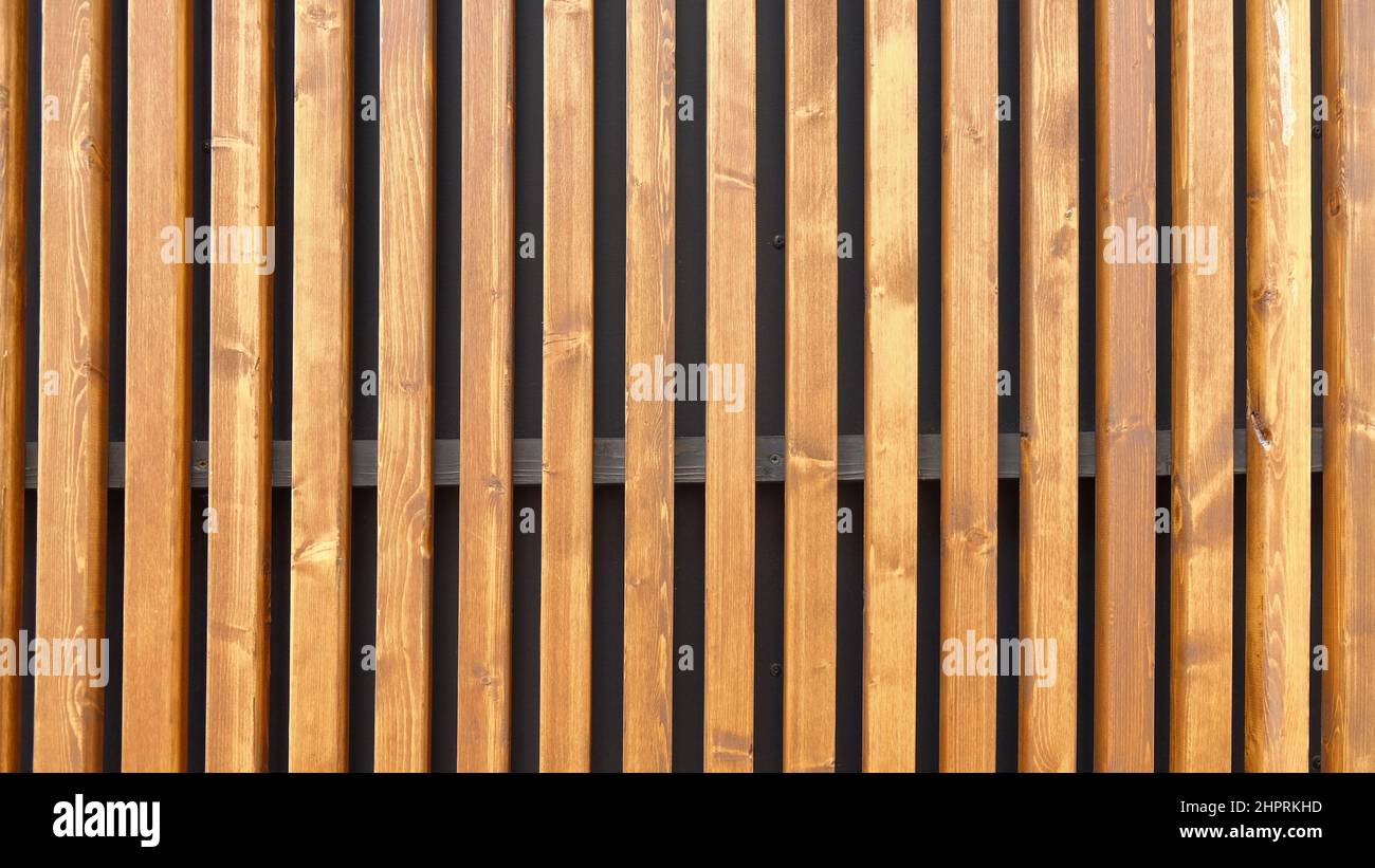 Modern outside wall covering with vertical wooden slats as background