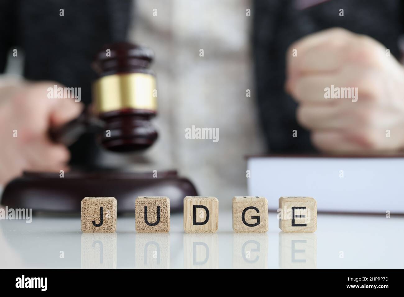 Male judge in courtroom hits with gavel and clenches fist Stock Photo