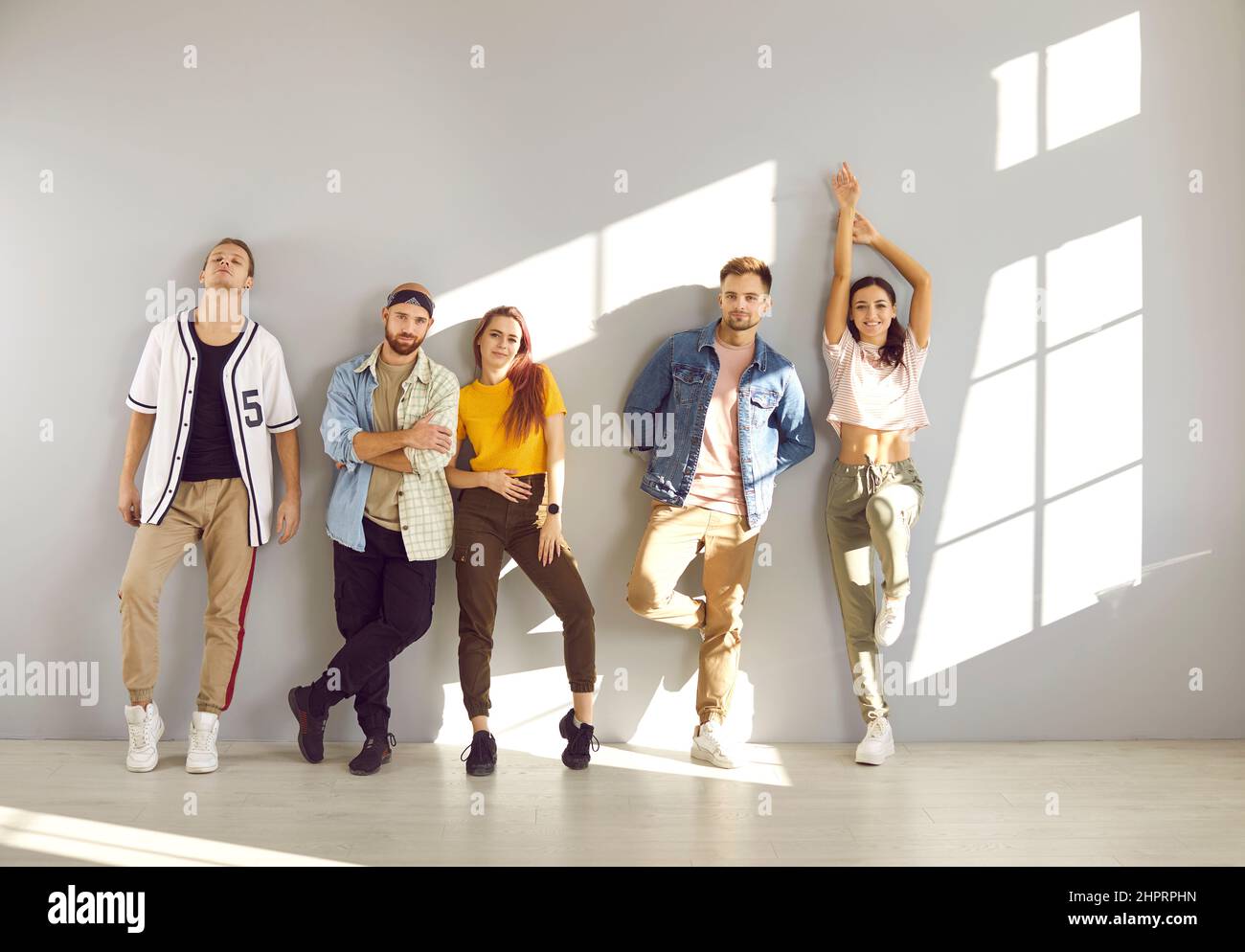 Group of young male and female models wearing casual clothes posing in the studio Stock Photo