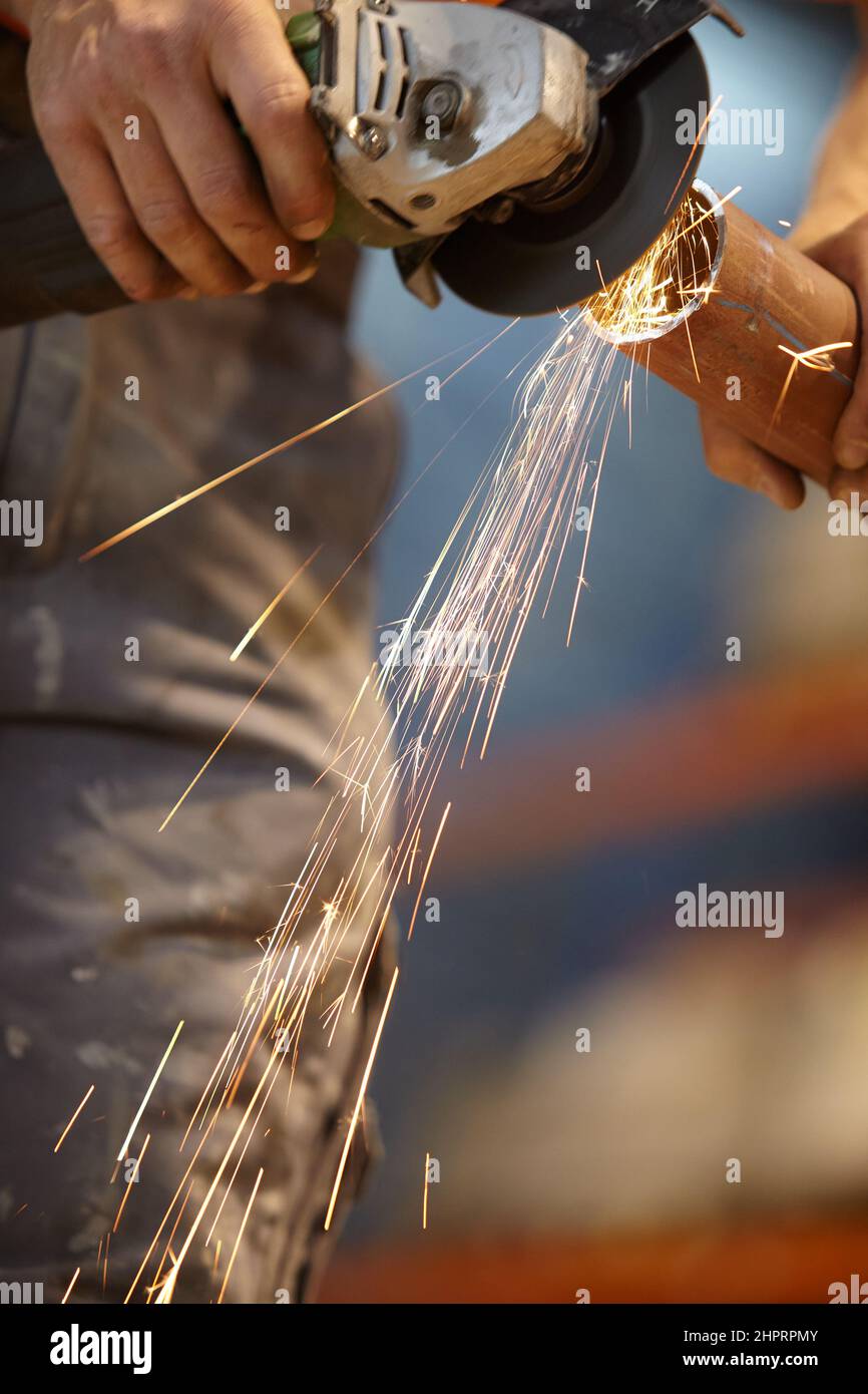 Photo in a mechanical factory, a hand doing welding. A weld to cut a