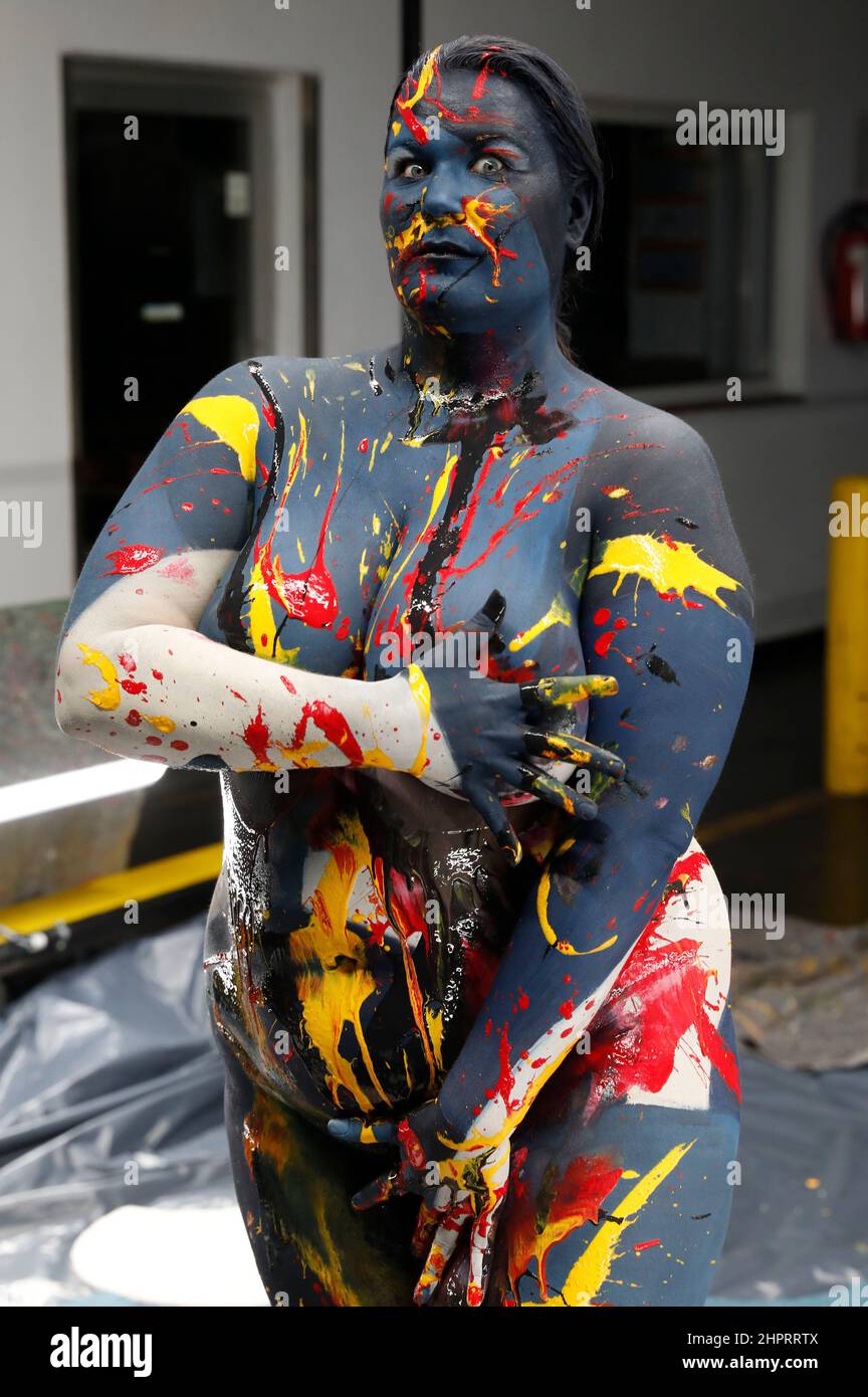 Bodyart artist Jörg Düsterwald has created a series of works of art on the subject of 'diversity' with various photo model types. In the production halls of the cooperating company Vorwerk flooring in Hamelin, he gave the plus-size model Nisi body painting to match the sponsored floor covering and then applied traces of liquid paint. Stock Photo