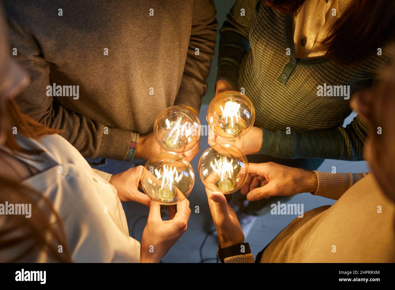 Motivated employees hold lightbulbs developing idea Stock Photo - Alamy