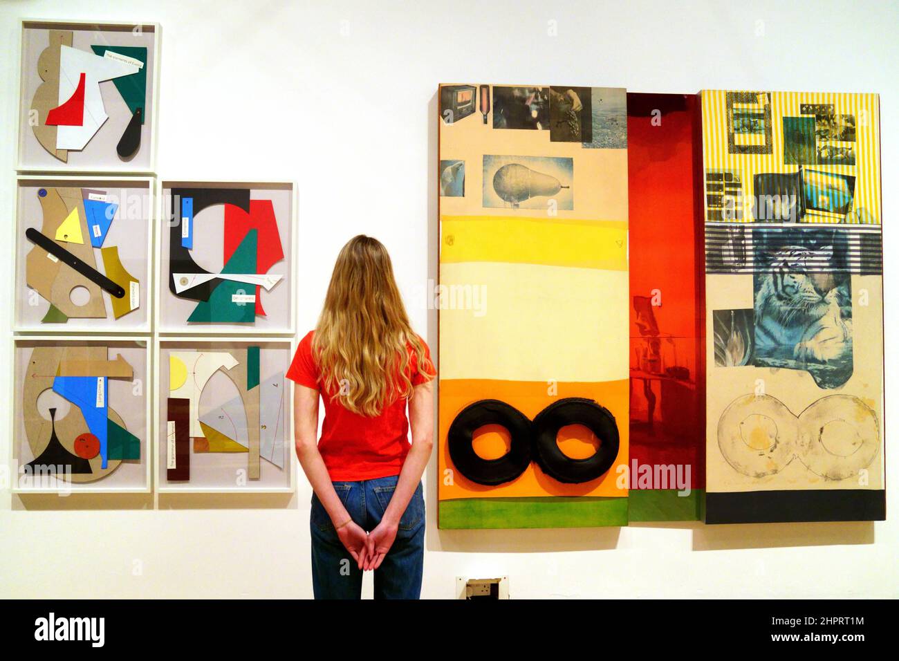 A gallery assistant poses with (left) The waste of my time: Composition, 2020, by Mateo Lopez, and (right) Ruby Re-Run, 1978, by Robert Rauschenberg, during a preview for A Century of the Artist's Studio 1920-2020 exhibition, at The Whitechapel Gallery, east London, a 100-year survey of the studio through the work of artists from around the world. Picture date: Wednesday February 23, 2022. Stock Photo