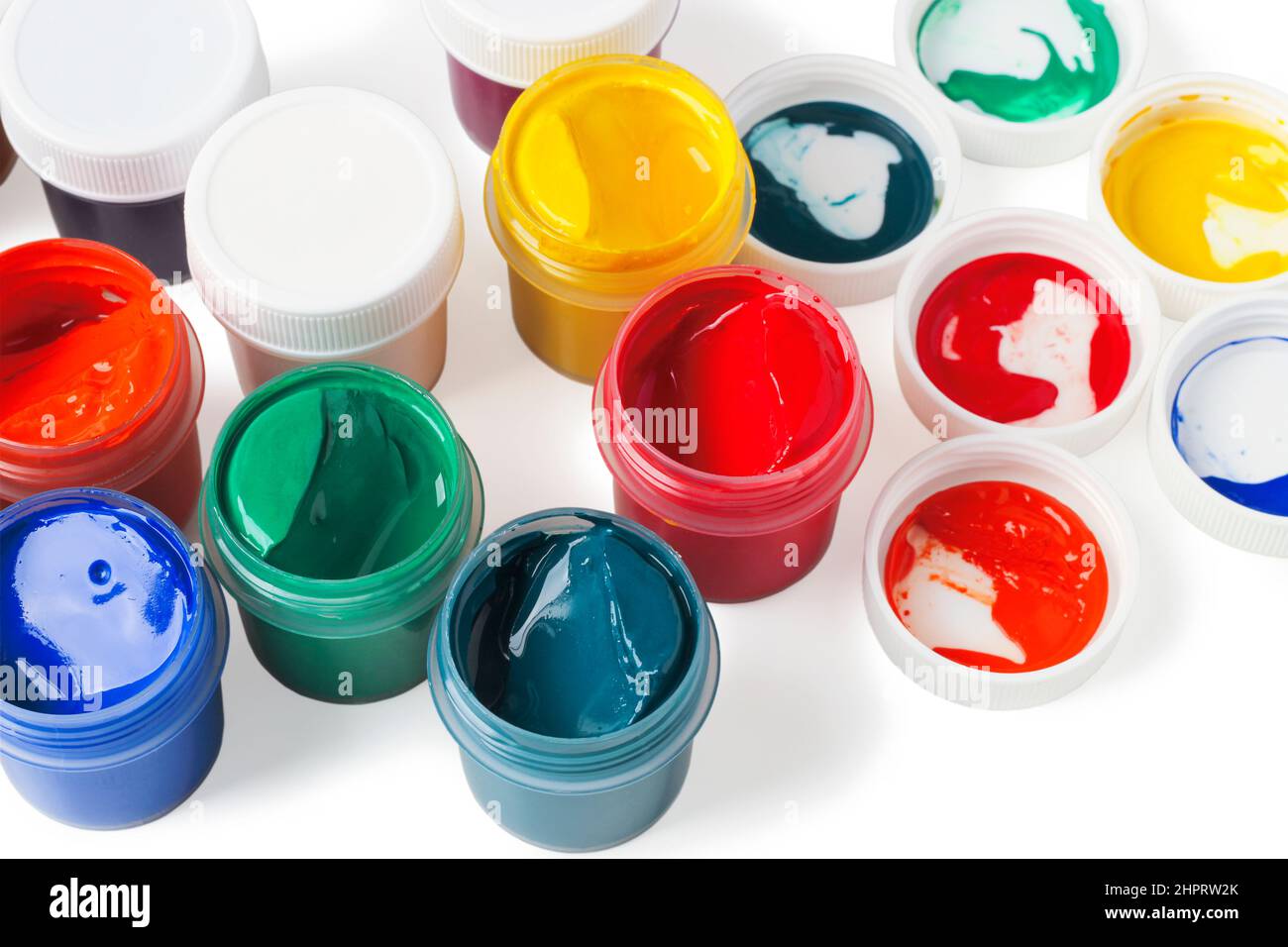 Multicolored gouache in plastic containers isolated on white Stock Photo