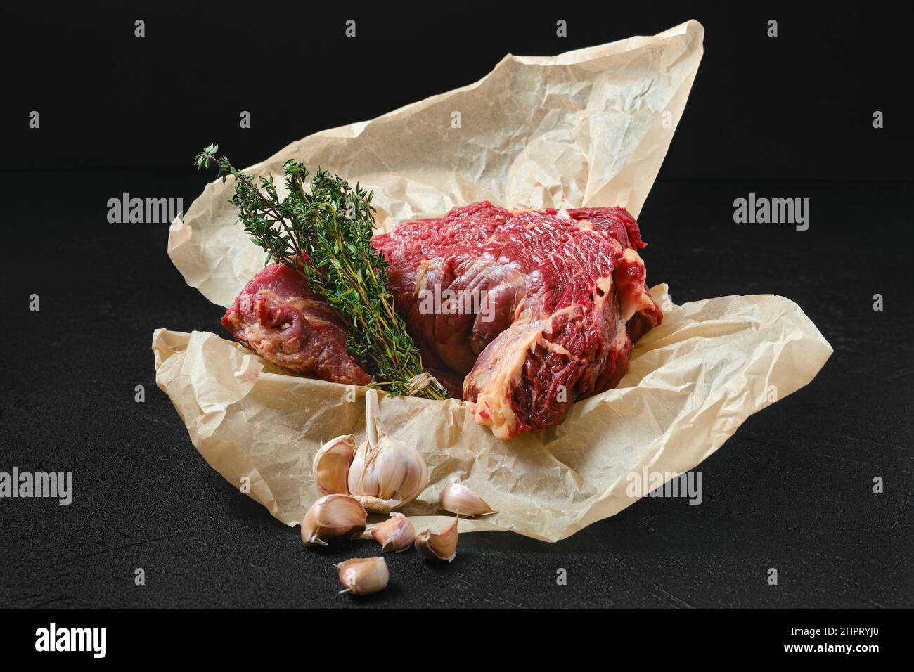 Raw beef neck with garlic packed in wrapping paper Stock Photo