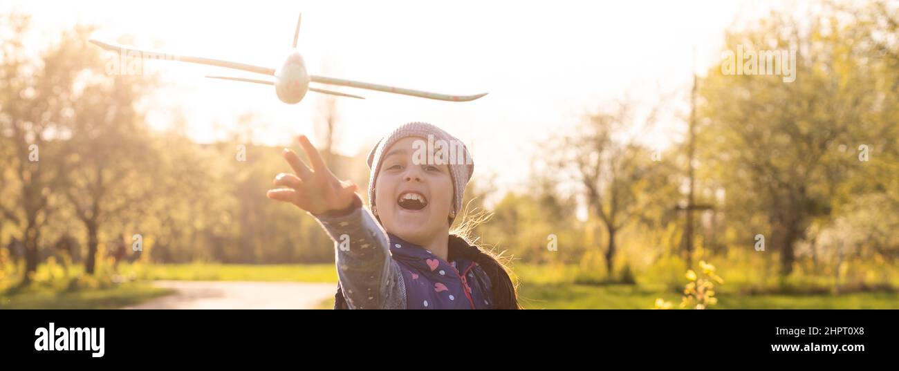 Child playing with plane. Happy girl play outdoors Stock Photo - Alamy