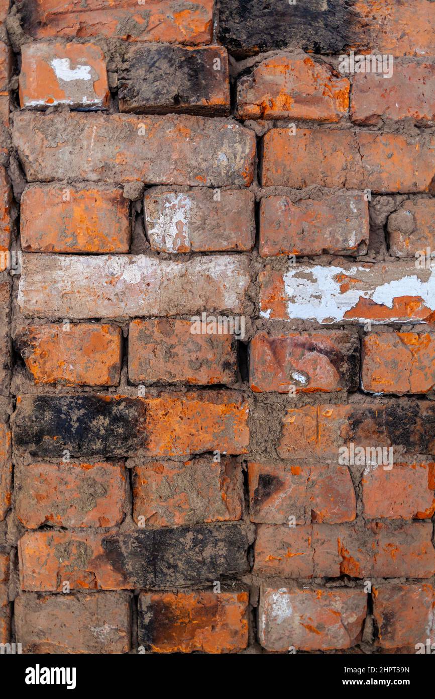 Repair of an old brick wall of a home stove. Different red bricks are