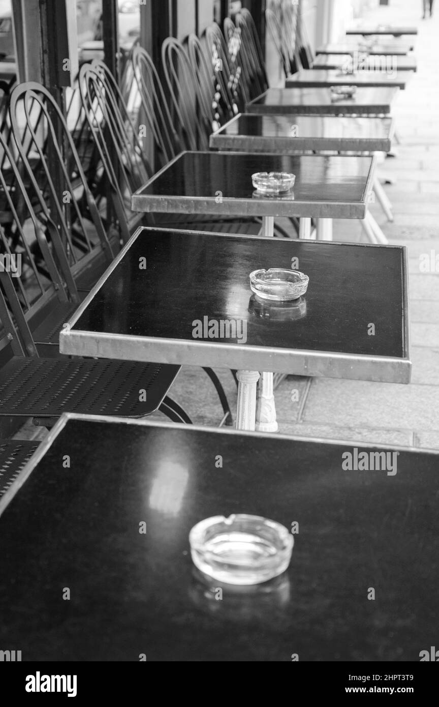 Empty terrace of a cafe. Empty glass ashtrays on tables. Paris, France
