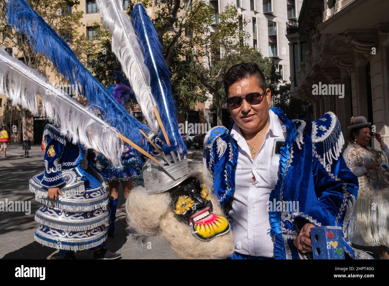 A guy in Bolivian traditional blue dress during Dia de la Hispanidad (Hispanic Day) a national public holiday in Spain. Gracia Avenue in Barcelona. Stock Photo