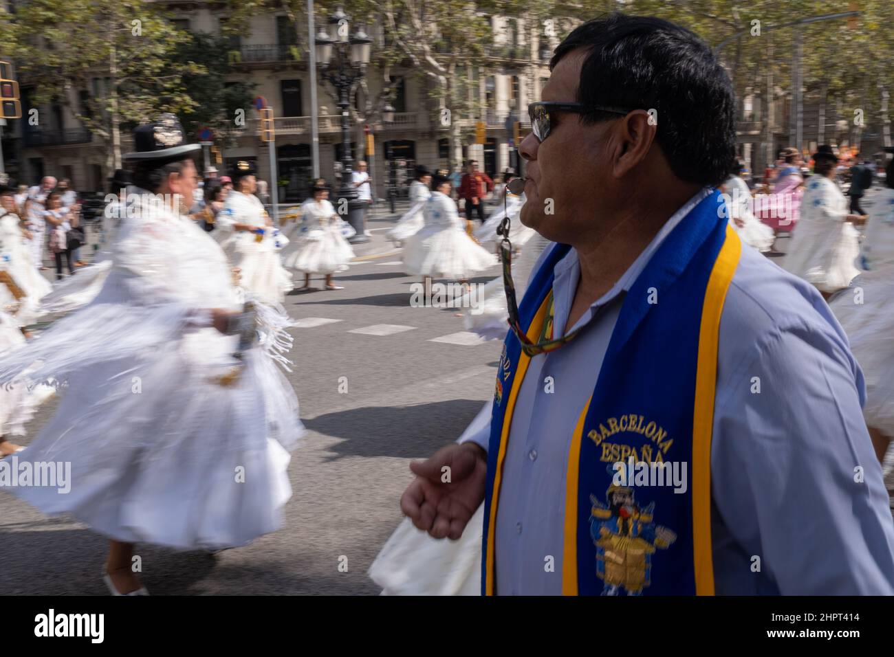 Dwaal veelbelovend genade Man dressed in Barcelona vest with a whistle in his mouth during Dia de la  Hispanidad at Gracia Avenue in Barcelona, Spain. Women in Bolivian dresses  Stock Photo - Alamy