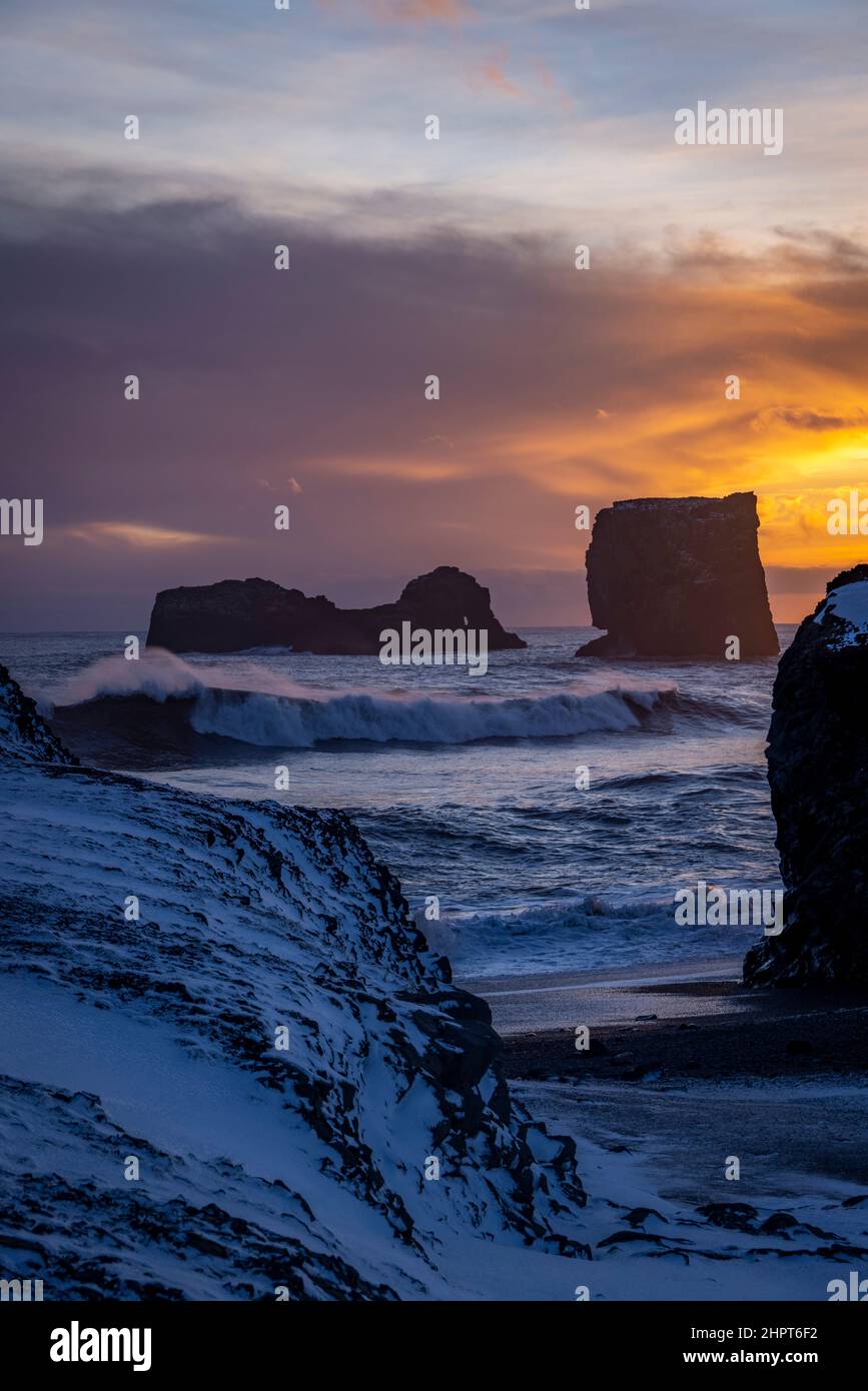view of rocks and stormy sea at sunset from Dyrholaey Peninsula, southeast Iceland Stock Photo