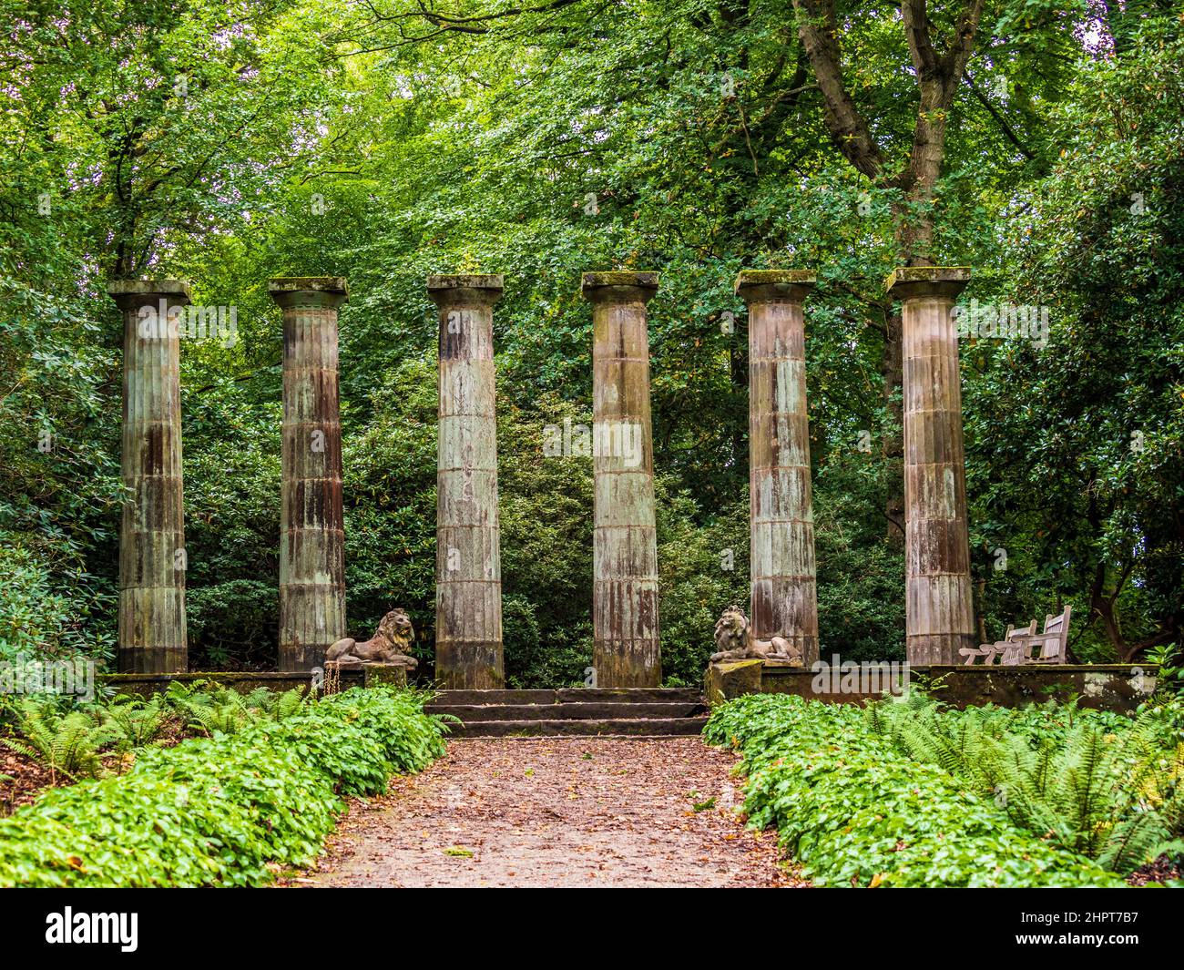 Doric columns and stone lions with woodland behind at Harlow Carr Gardens in Harrogate, North Yorkshire. UK Stock Photo