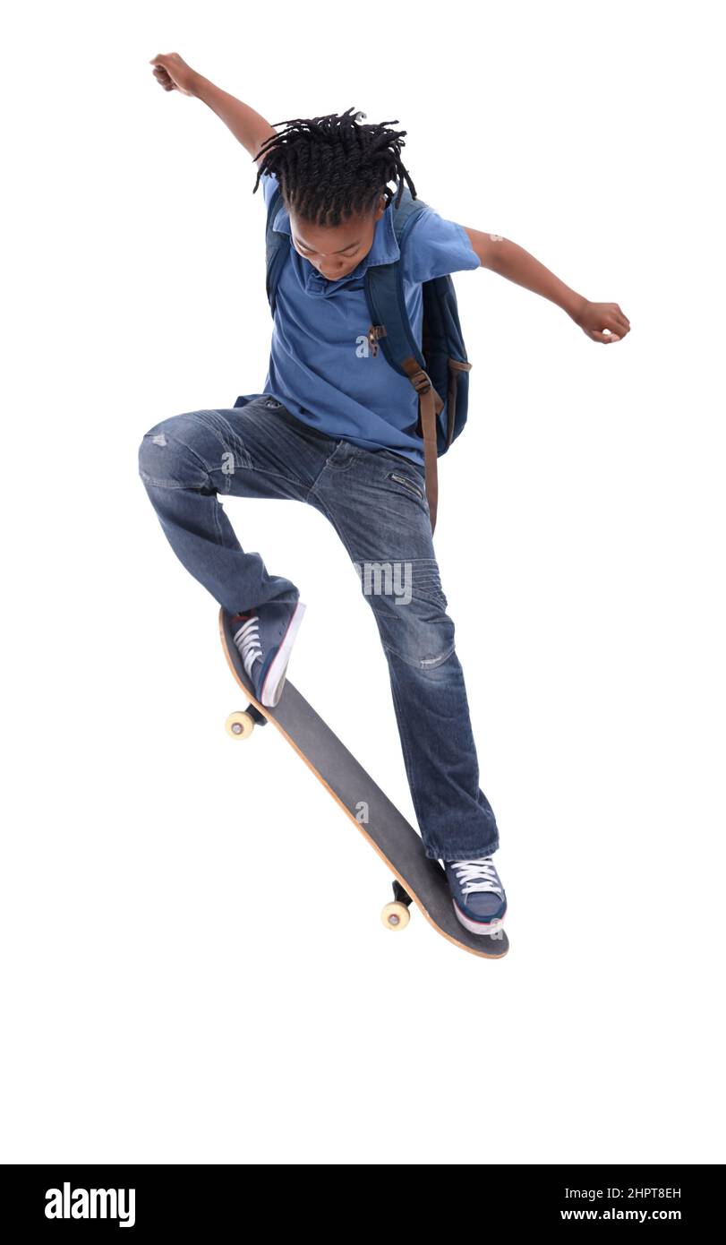 Showing off his mad skills. A young African-American boy doing a trick on his skateboard. Stock Photo