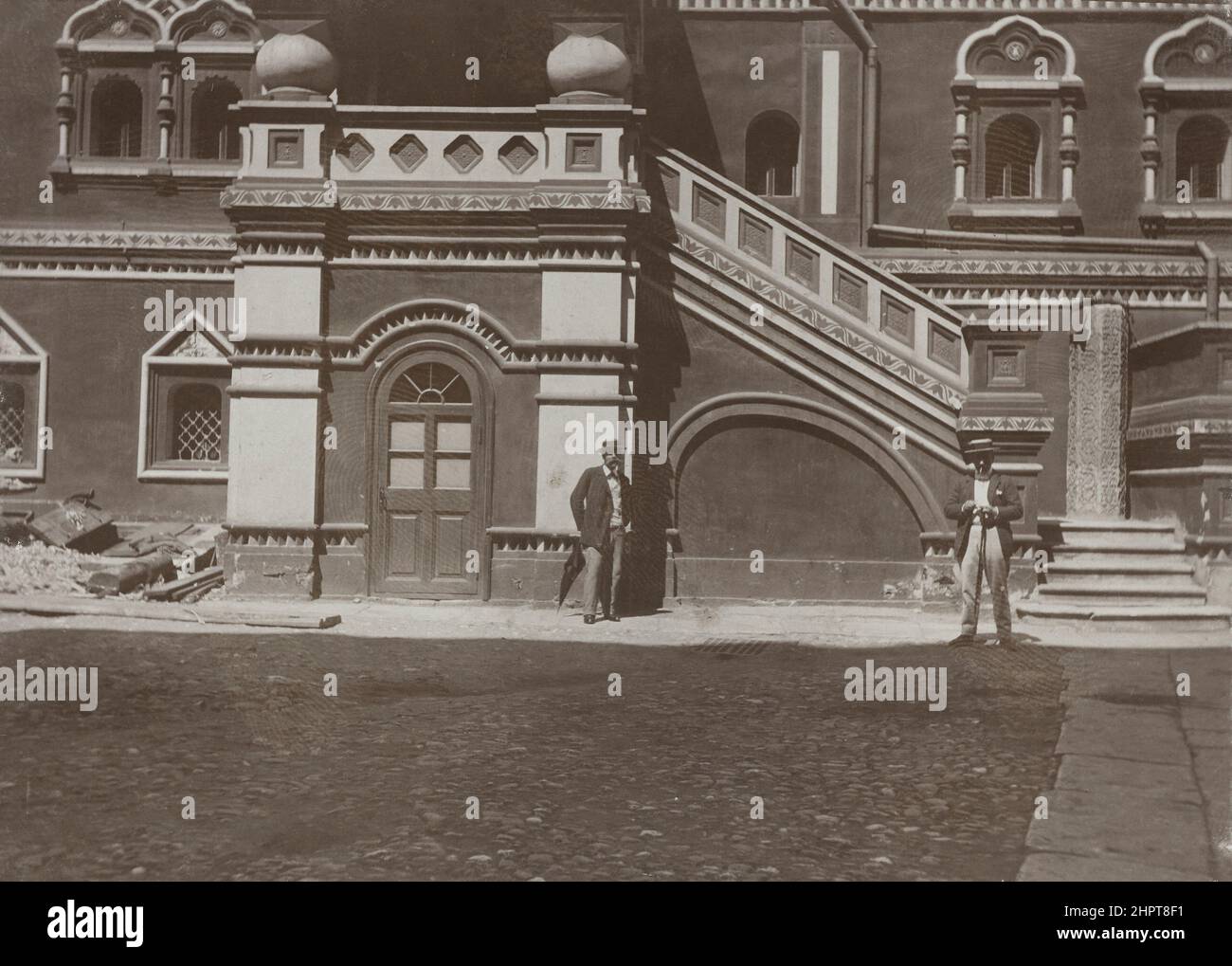 Vintage photo of Kitay-gorod in Moscow. Two men at the door of the Printing House of the Synod of the Russian Orthodox Church on Nikolskaya Street. Ru Stock Photo