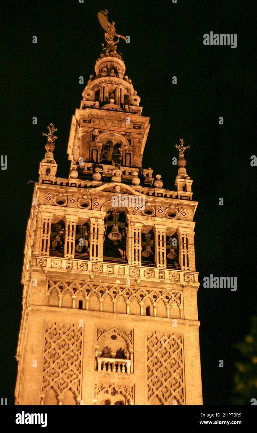 Giralda Tower at Night: A night view of a flood lit Giralda Tower originally a minaret was converted into a bell tower It is topped with a statue representing Faith The Giralda is the city s most famous symbol Stock Photo