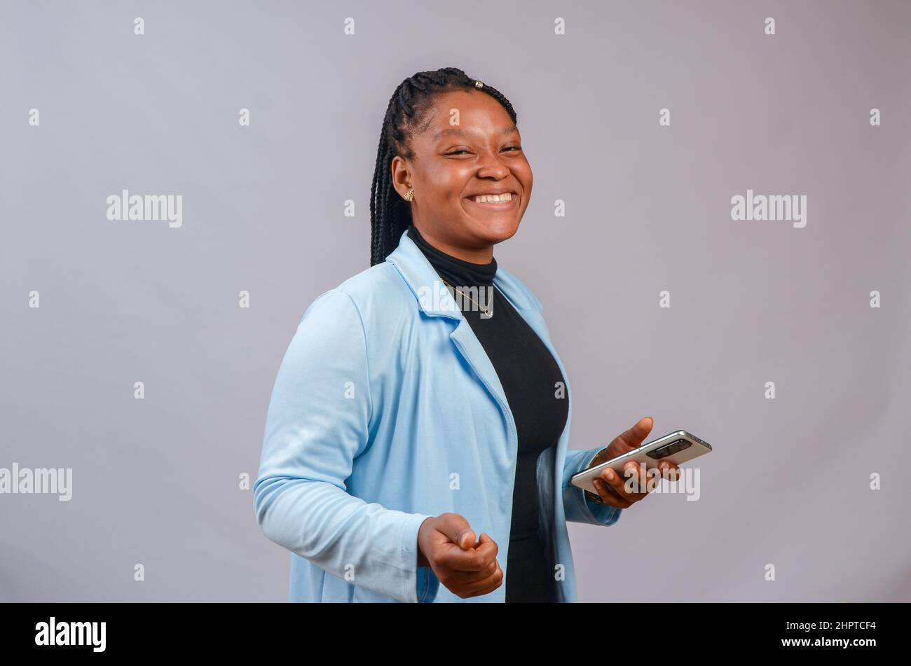 Overexcited beautiful African with a phone on white background Stock ...