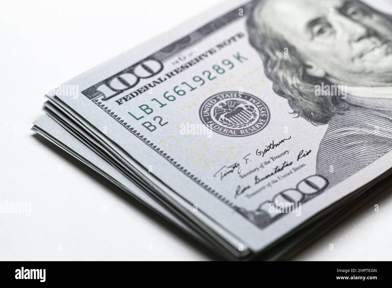 Bundle of One Hundred Dollars lays on white background, The United States currency USD close up photo with selective focus on The Federal Reserve Syst Stock Photo