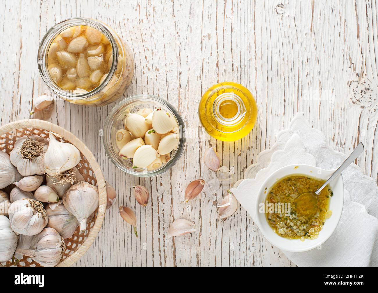 Garlic aromatic flavored oil or infusion bottle and garlic cloves. Garlic cooking Stock Photo