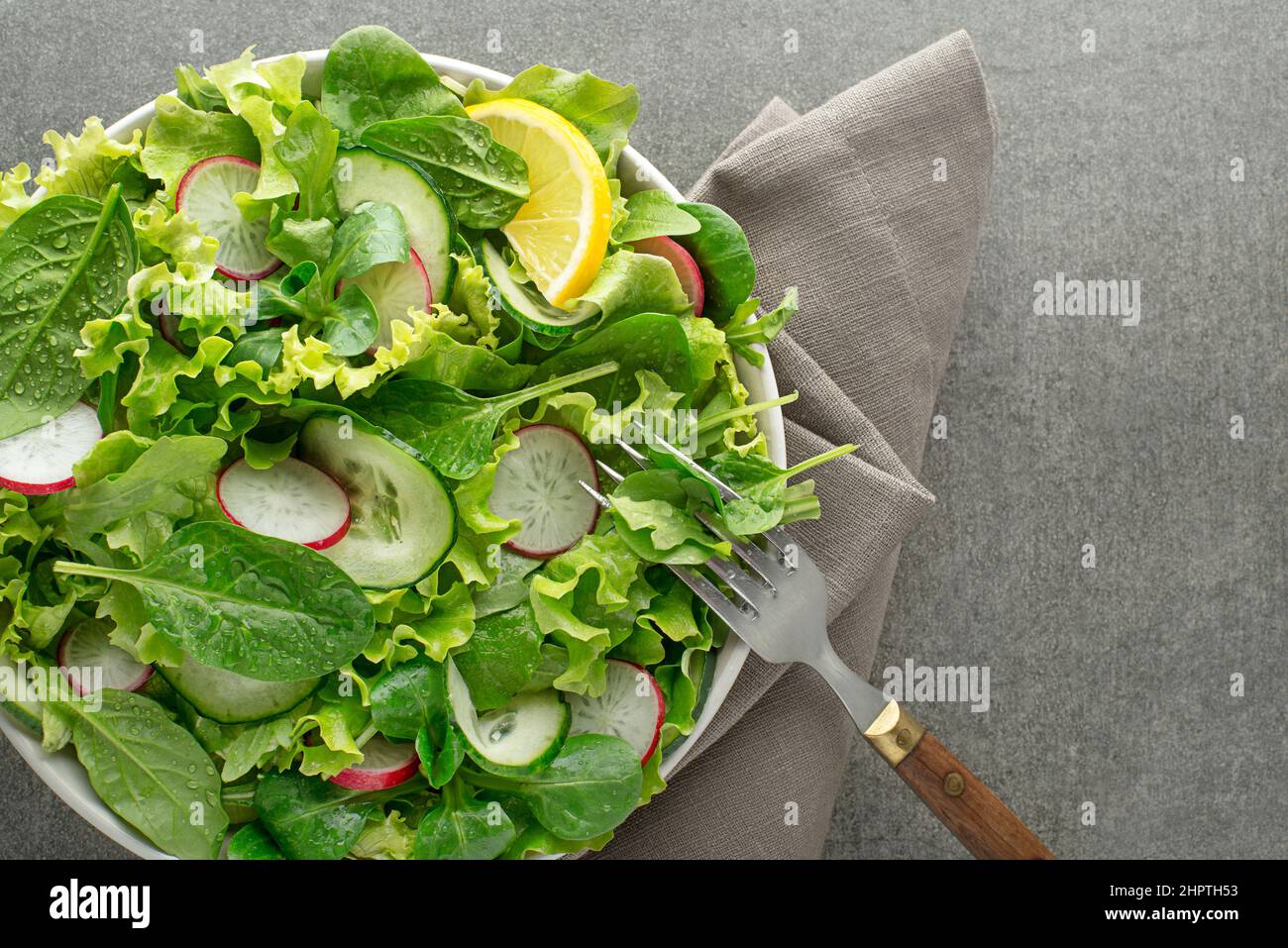 Healthy Green salad with fresh vegetables on grey table background Stock Photo