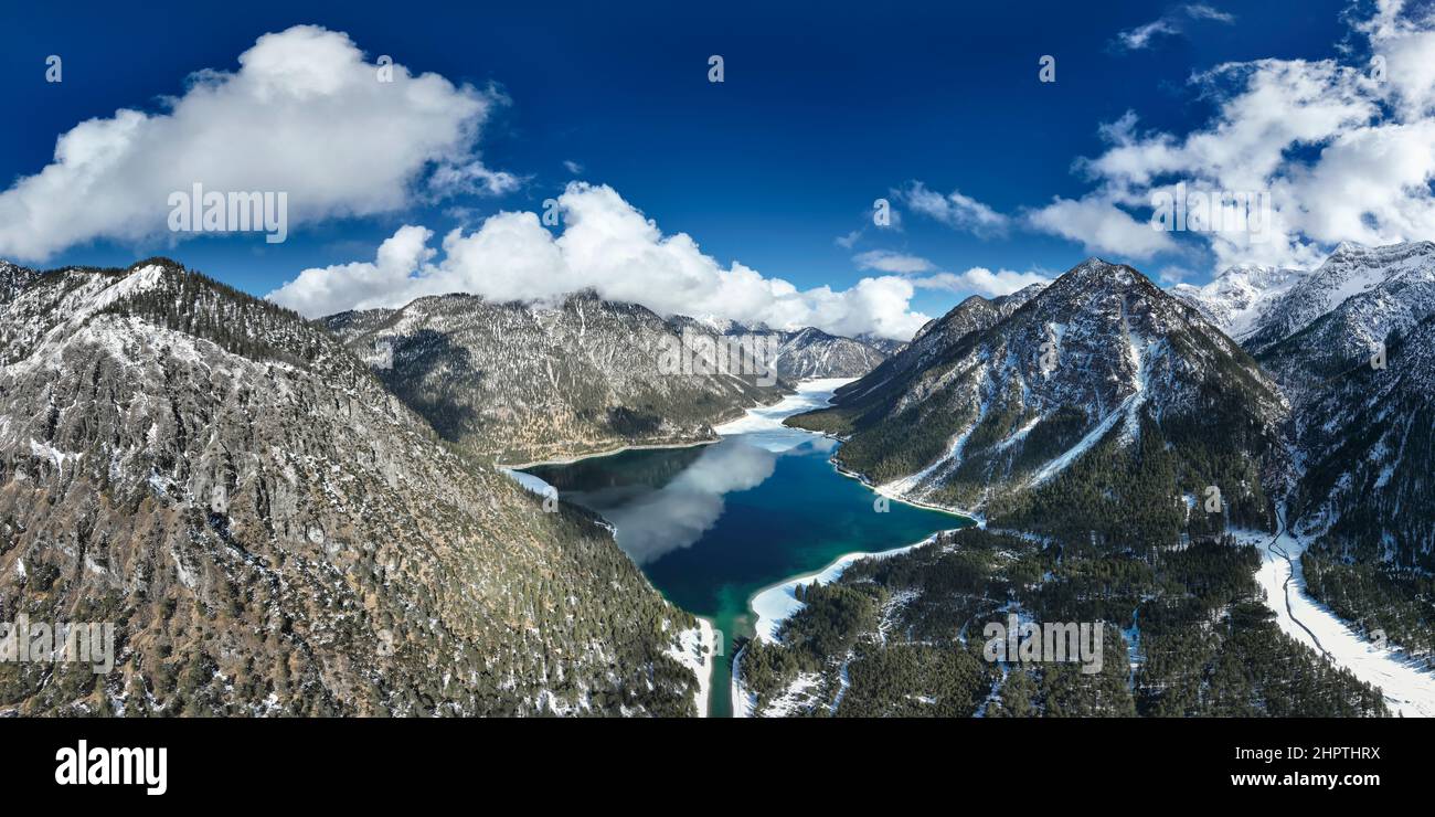 crystal clear cold lake water from plansee in thawing weather with blue sky and clouds near reutte Stock Photo
