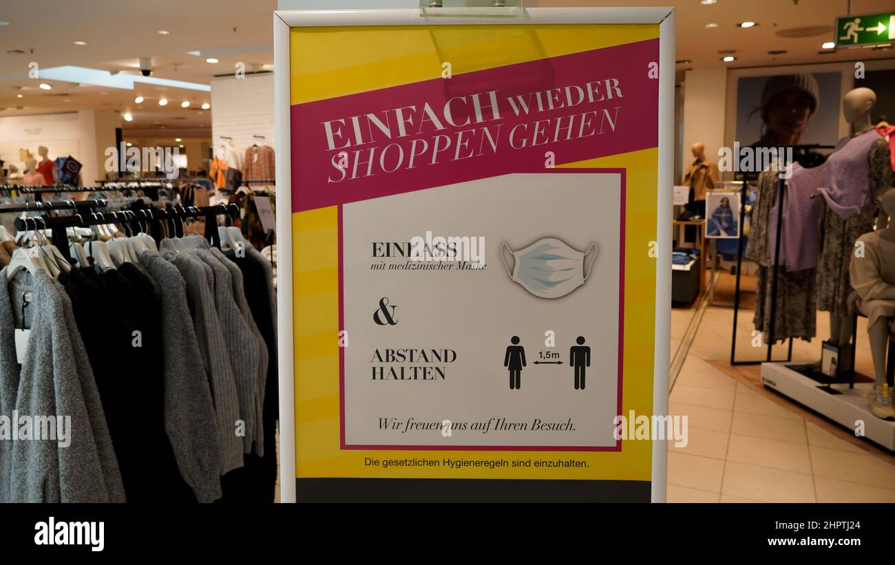 Corona-Warnhinweis, Abstand zu halten und eine Maske zu tragen, an einem Geschäft in Deutschland Stock Photo