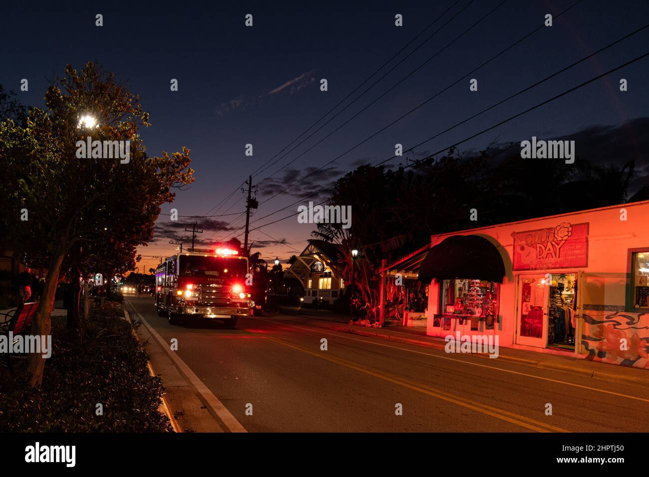 A fire truck with lights flashing travels a street at twilight  in Key West, Florida, USA. Stock Photo