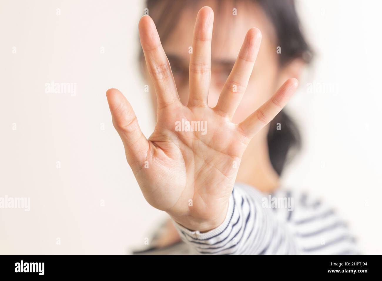 Hand gesture Stop, No. Woman rises her hand up, covering her face and