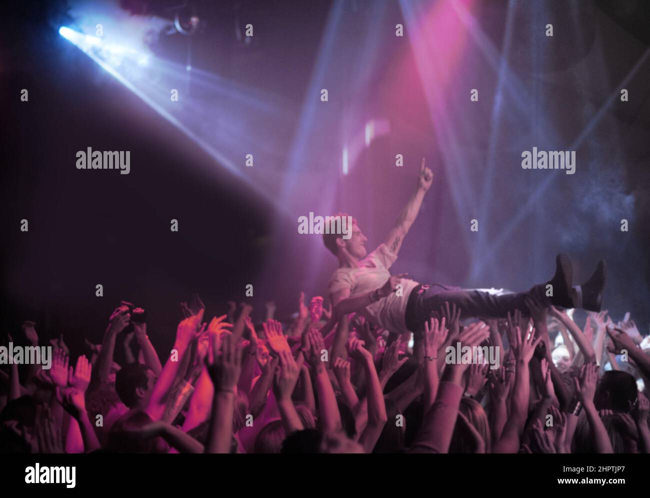 Surfing on a wave of praise. A stage diver being carried across the audience at a rock concert. Stock Photo