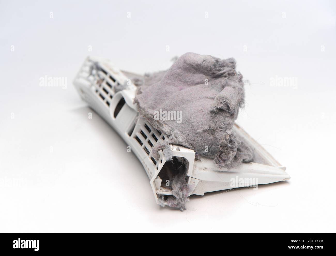 A tumble drier fluff filter catcher full of clothing fluff on a white background Stock Photo