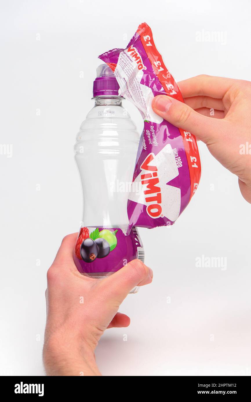 Removal of label for recycling on a single use Vimto plastic bottle