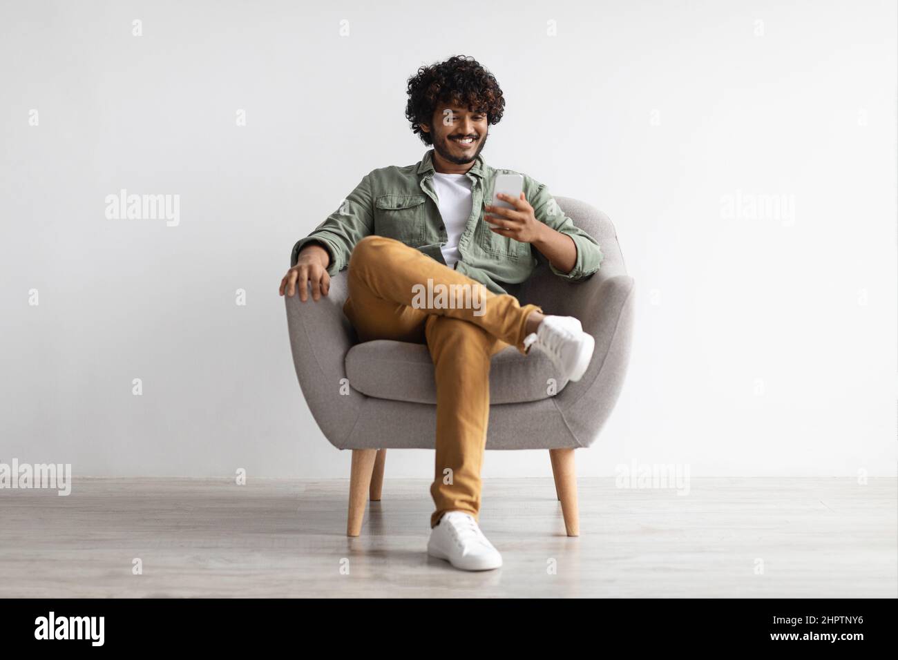 Handome young indian man chatting with girlfriend, using smartphone Stock Photo