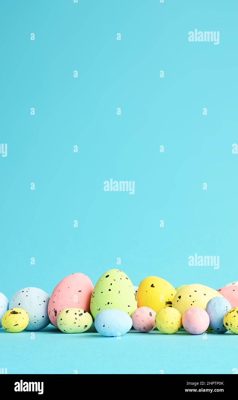 Row of painted colored easter eggs on blue background. Happy Easter background. Stock Photo