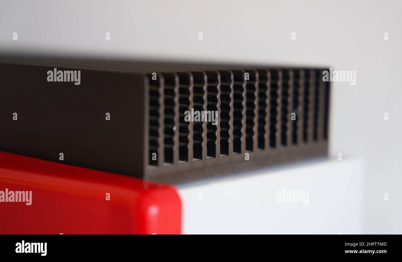 Close up of a red solar power inverter mounted to a white wall Stock Photo