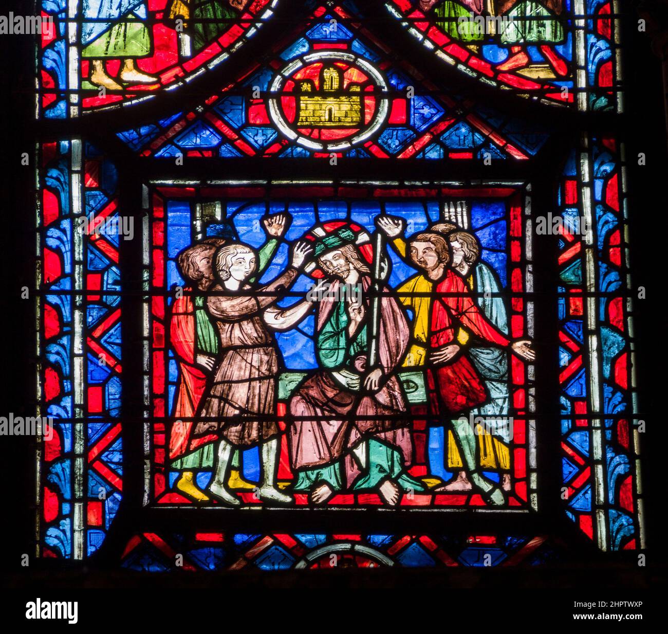 All Hail the Christ in Stained Glass: Detail fom an ancient stained glass window in Sainte Chapelle. A crowd of men surround a sitting figure of Christ welcoming or prasing him. Christ holds up a two finger victory salute. Stock Photo