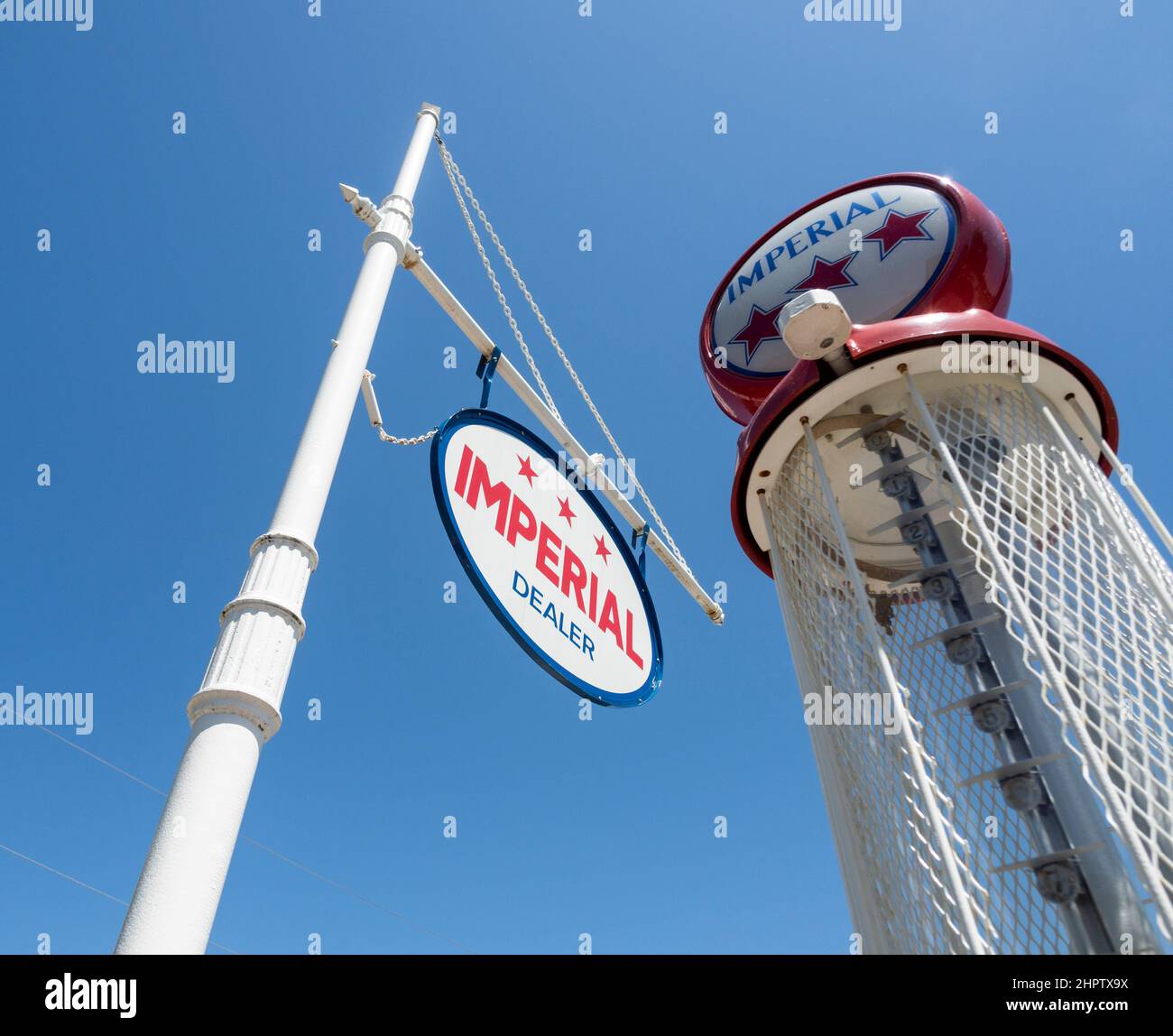 Vintage Imperial Gas Pump: An Imperial sign with an old gas pump behind against a bright blue sky. Stock Photo