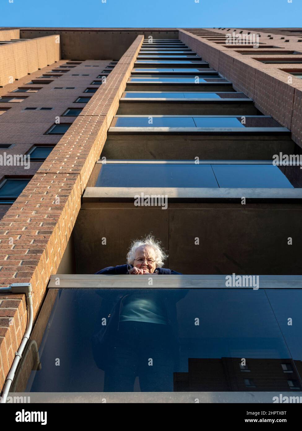 Locked down in a Retirement home during a Pandemic: A senior woman stares out from her balcony in an Ottawa retirement home during the 2020-2021 global COVID-19 pandemic. Stock Photo