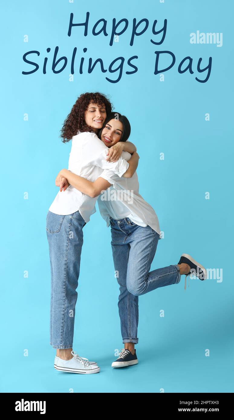 Happy sisters hugging on blue background. Happy Siblings Day Stock ...
