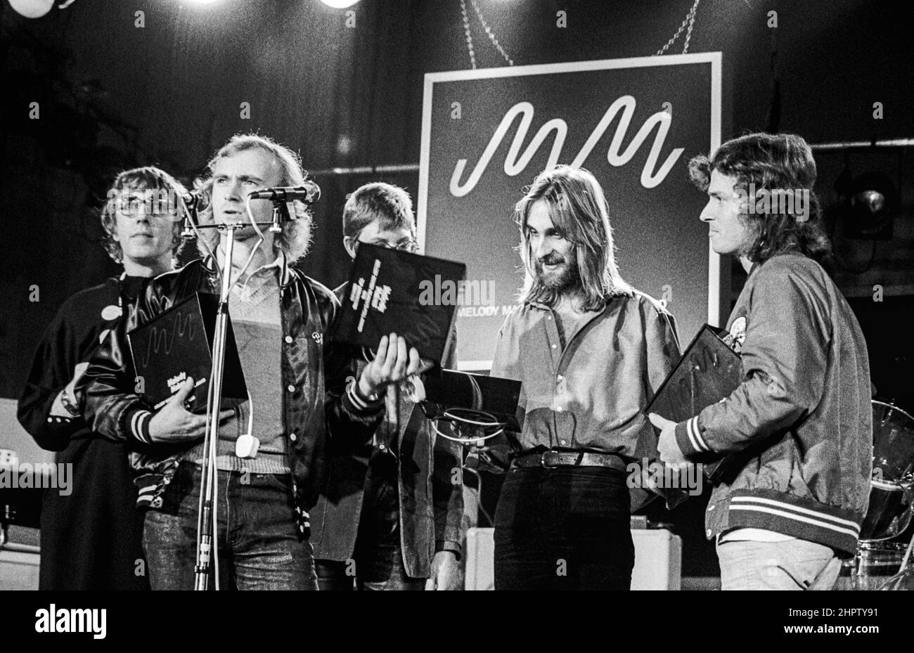 English band Genesis collecting an award at a Melody Maker Poll Awards ceremony in London in 1978. Comedian Peter Cook is in the backgound. Stock Photo