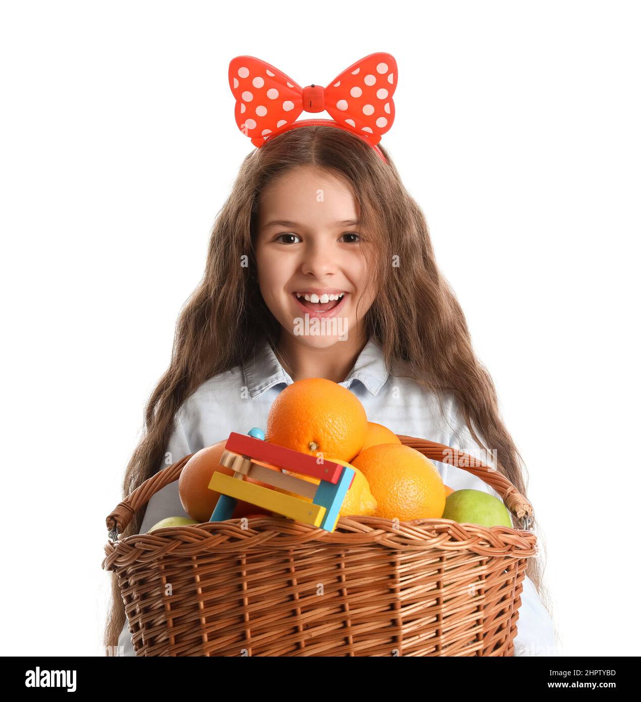 Happy little girl with basket of fruits on white background. Purim
