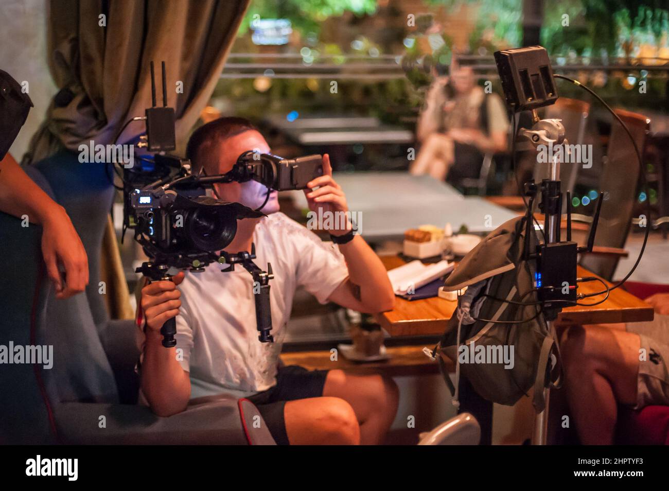 Behind the scenes. Cameraman shooting the film scene with camera on indoor set. Photography