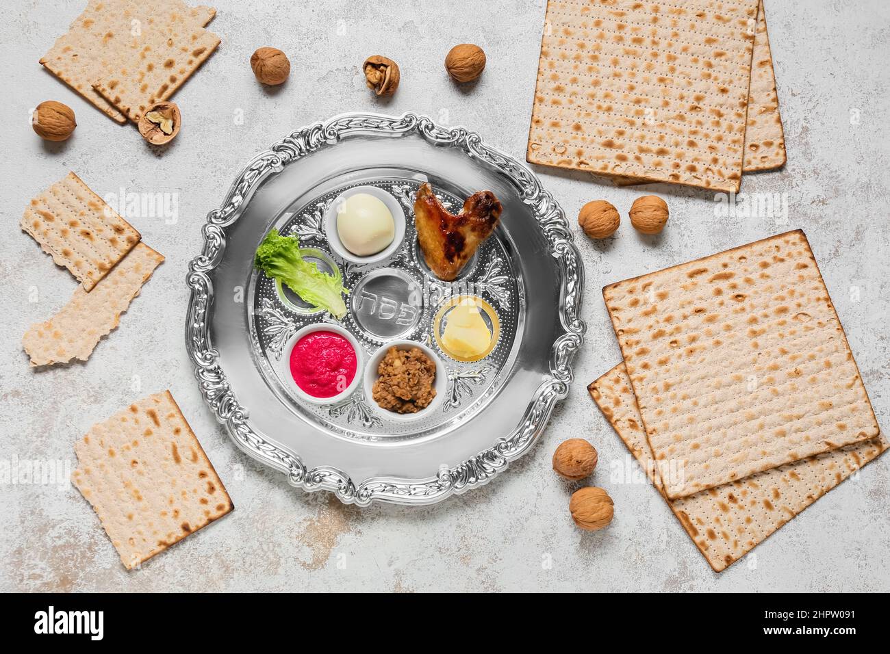 Passover Seder plate with traditional food, walnuts and matza on light ...