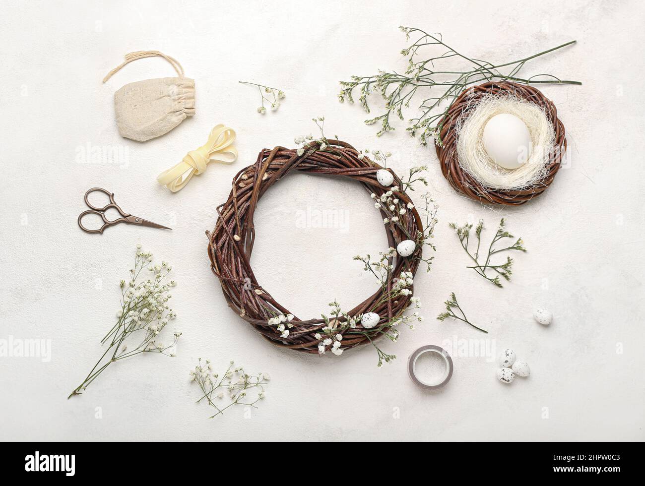 Beautiful Easter wreath with floral decor and nest with egg on light ...