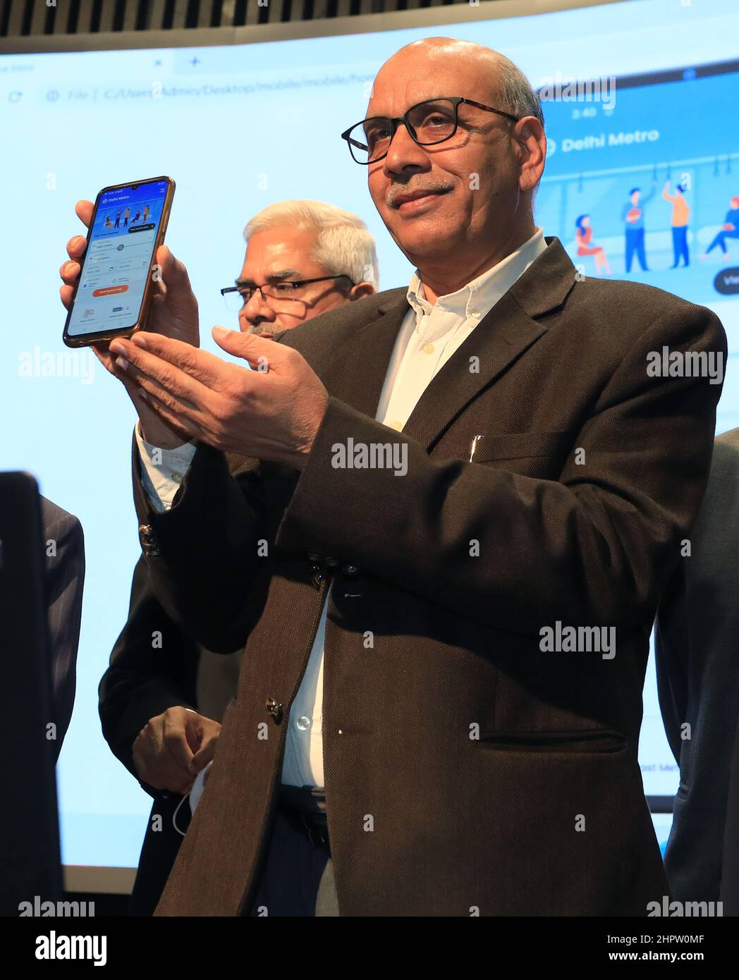 New Delhi, India. 23rd Feb, 2022. Delhi Metro Rail Corporation (DMRC), Managing Director, Mangu Singh holds a mobile phone during the launch of the revamped official website and Mobile application at Metro Bhawan.The new Website and Mobile application are loaded with many new advanced features such as interactive route maps, advanced station search options, real time first and last train time calculator, next and nearest station alert on the app etc. Credit: SOPA Images Limited/Alamy Live News Stock Photo