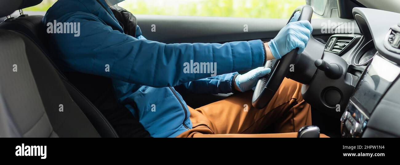 Covid19 concept. Man drives in car, wears medical gloves, protects