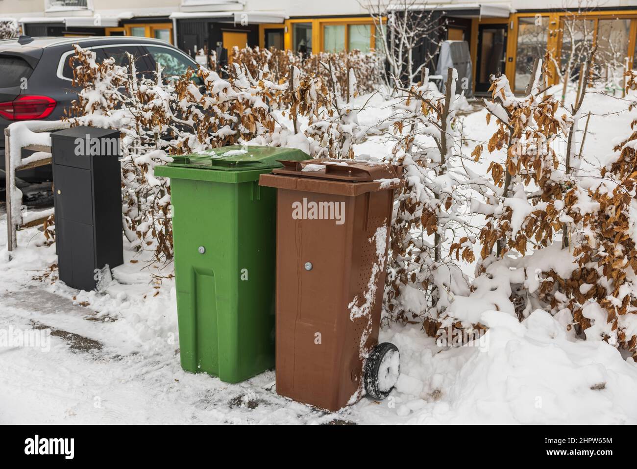 Close up view of car parking in private house and two trash cans for