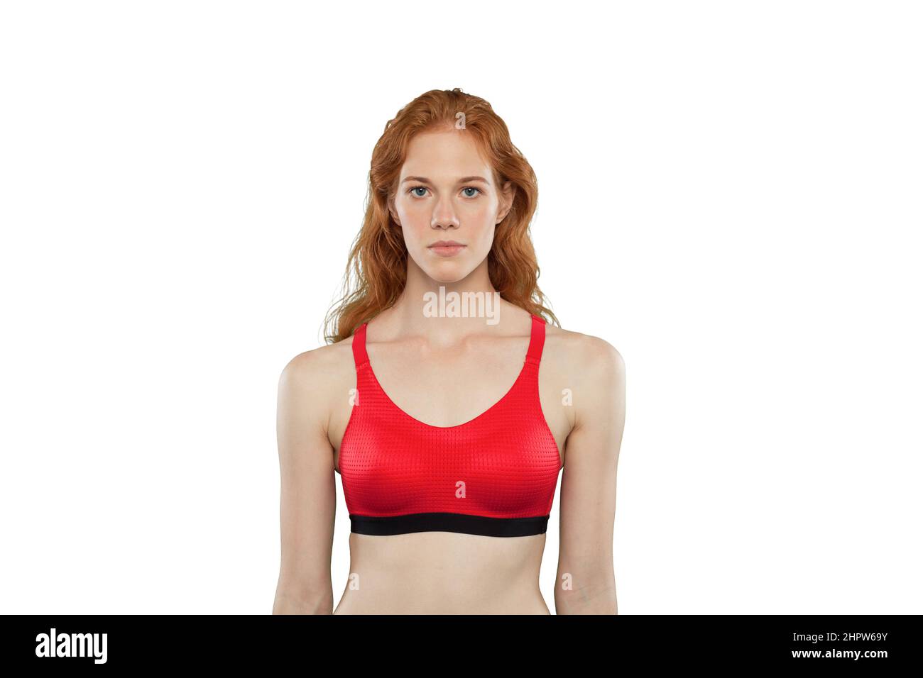 Female athlete poses on a white background. Studio portrait of woman wearing red sporty tank top. Woman in a calm pose Stock Photo