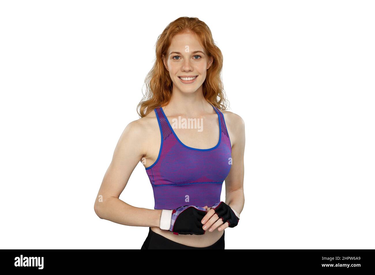 Red female athlete wearing training gloves and tank top. Smiling sporty woman poses on white background. Stock Photo
