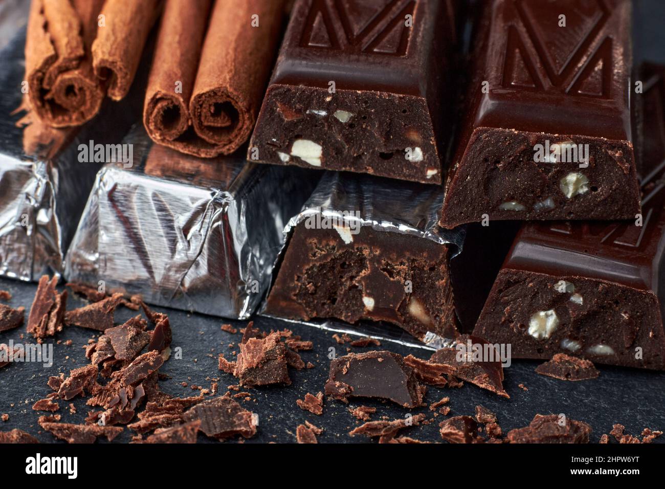 Dark chocolate bars with chopped almonds and cinnamon sticks Stock