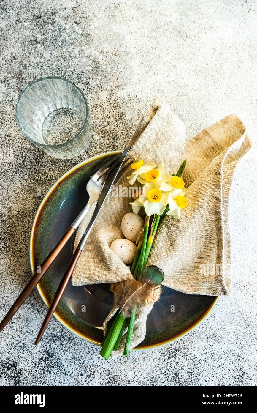 Minimalistic table setting for easter festive dinner  decorated with daffodil flowers Stock Photo