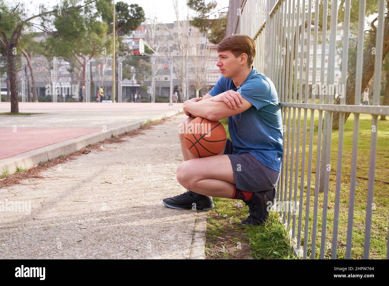 young athlete resting after playing basketball. Stock Photo